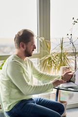 a beautiful white-haired man works at a laptop on self-isolation. remote work