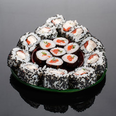 Japanese sushi food. Maki rolls and uramaki with tuna, salmon, caviar and cucumber. The roles are outlined in avocado form.