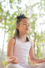 calmness and relax, female happiness.Horizontal, blurred background. little asian girl meditates while practicing yoga. freedom concept. calmness and relax, child happiness. toned picture healthy life