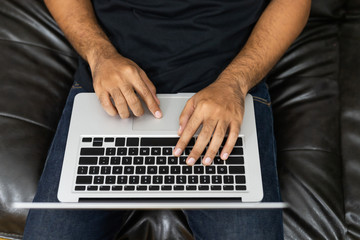 Fototapeta na wymiar Close up male hands using laptop work from home sofa