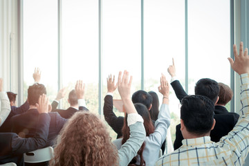 Business people raising hand up to ask question with speaker in seminar conference, raise hands up to agree or vote for comments in the meeting - obrazy, fototapety, plakaty