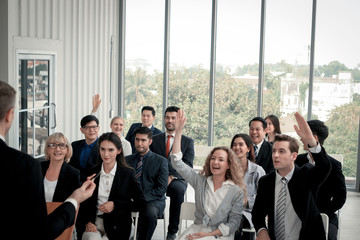Group of business people sitting on conference together listening to the speaker giving a speech in...