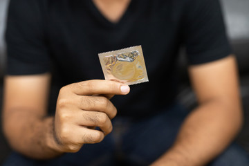 Close up Male hand holding Condom. Safe sex concept.