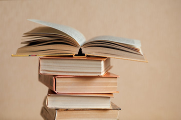 a stack of books on the table and one book is opened
