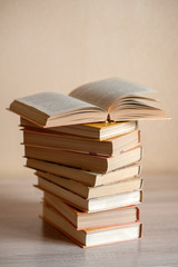 a stack of books on the table and one book is opened