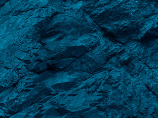 Blue green rock background. Toned mountain texture. Close-up. The combination of dark turquoise color and volumetric stone texture. 3D effect.