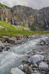 Wild creek and waterfalls in the swiss alps at Klausenpass at Canton Uri in Switzerland (vertical)