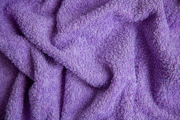 Purple Terry cloth or towel in a fold, close-up. Textile background.