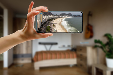 Tourism from home concept. Travel to Copacabana beach via smartphone.