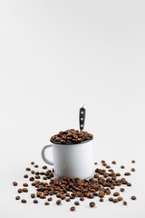 White metal travel hiking hipster cup full of freshly roasted coffee beans