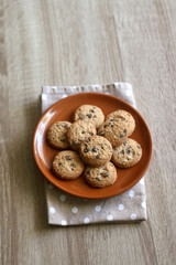 Chocolate chip cookies and polka dot napkin on wooden table. Selective focus.