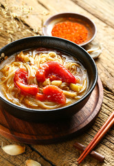 tomato noodles in black bowl on wooden table