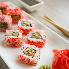 Sushi with chopsticks, ginger, soy sauce and wasabi. Japanese food. Sushi roll set with vegetables, fish and caviar. Japanese restaurant menu