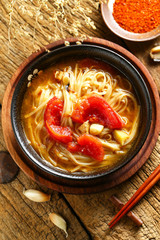 tomato noodles in black bowl on wooden table