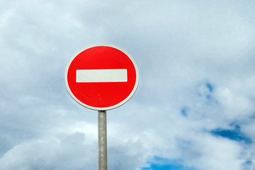 International traffic sign 'No Entry' or 'No Entrance' on blue cloudy background
