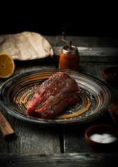 Raw beef tenderloin with greens and seasonings