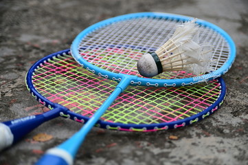 Close-Up Of Shuttlecock On Badminton Racket Against Floor.