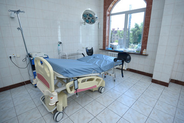 Obstetric bed at the delivery room of the maternity hospital, medical equipment set