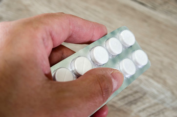 pills in a blister pack in hand. Close-up.