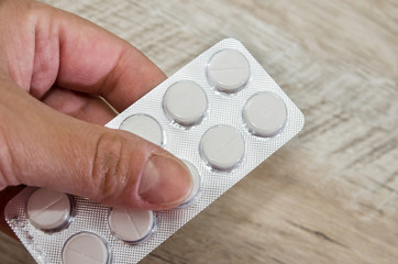 pills in a blister pack in hand. Close-up.