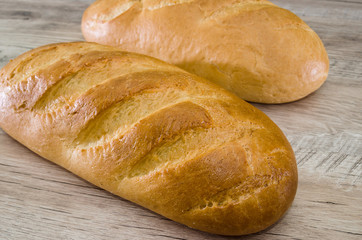 Two loaves on a wooden background. Close-up. White Ukrainian bread.