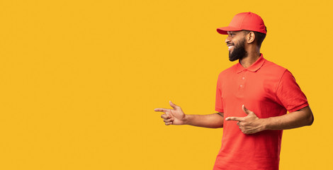 African Courier Pointing Fingers Aside Recommending Delivery Service, Yellow Background