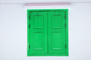 Green Wooden door on white wall texture background - abstract surface with copy space                                