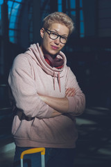 Portrait of a beautiful woman with glasses in the setting sun of a modern airport