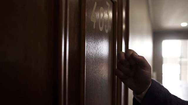 A man knocks on a hotel room number 403