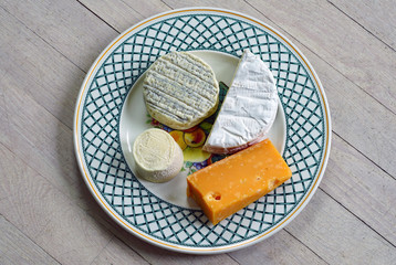 A gourmet cheese platter with ripened goat cheese, camembert and aged gouda