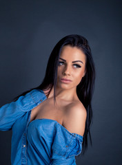 Attractive brunette woman posing to camera in blue shirt