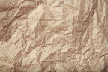 Crumpled beige paper texture closeup