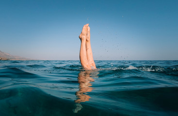 The legs of a freediver girl in the sea.