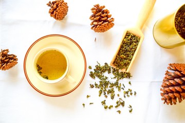 Aromatic green dry tea spread on the table. Top view of green tea served with tea cup.