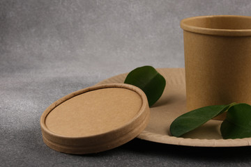 A set of eco-friendly utensils with green leaves on a concrete background. The concept of eco-friendly utensils. Copy space.Close-up.
