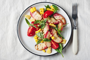 Salad with grilled peaches, corn,  tomatoes and basil.