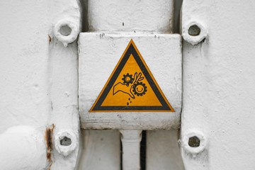 Warning sign about hands trapped between gears of a sluise gate