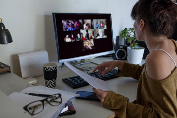 portrait of a young woman with glasses working at home, the woman is making a video call