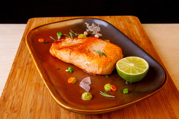 cooked fried fish on a plate with vegetables