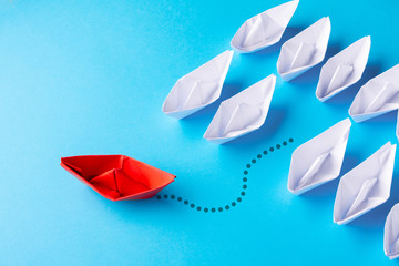 Leadership concept using red paper ship among white