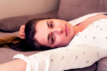 Young elegant woman posing lying on couch