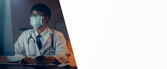 The doctor wearing mask is sitting at a desk at the night, Which is researching how to treat the...