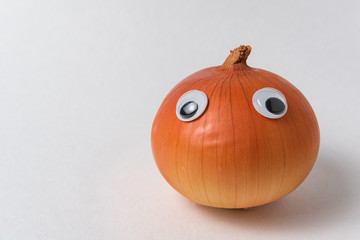 Onion with Googly eyes on white background. Food with funny face
