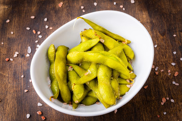 Close-up of edamame in a bowl on a rustic tabletop