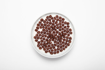 Ceramic plate with chocolate cereal balls isolated on a white background

