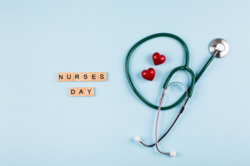 National Nurse Day Holiday Background. Medical stethoscope, two red hearts and wooden letters text. Healthcare medicine concept. Top view, flat lay.