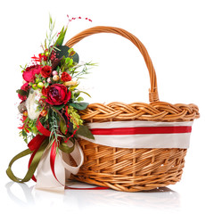 Fototapeta na wymiar Decorated with a basket of natural vines. Decor with red flowers, green and ribbon. Isolated.