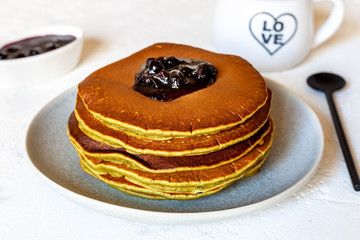Pancakes with jam and a black coffee, close-up