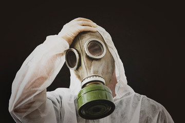 virus infection concept. Man in protective suit and antigas mask on dirty black background. Ebola,...