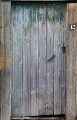 Brown wooden door to the staircase. Old peeling paint